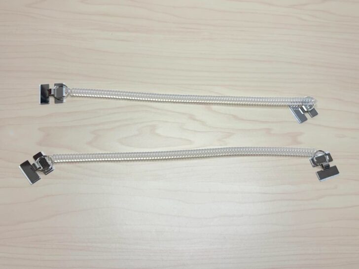 樹脂製の透明な伸びるコイルでつながれたストラップで、両端がアルファベットの「H」の形をした金具になっている